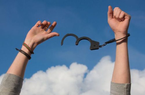 Metaphorical handcuffs breaking free of debt by means of debt consolidation